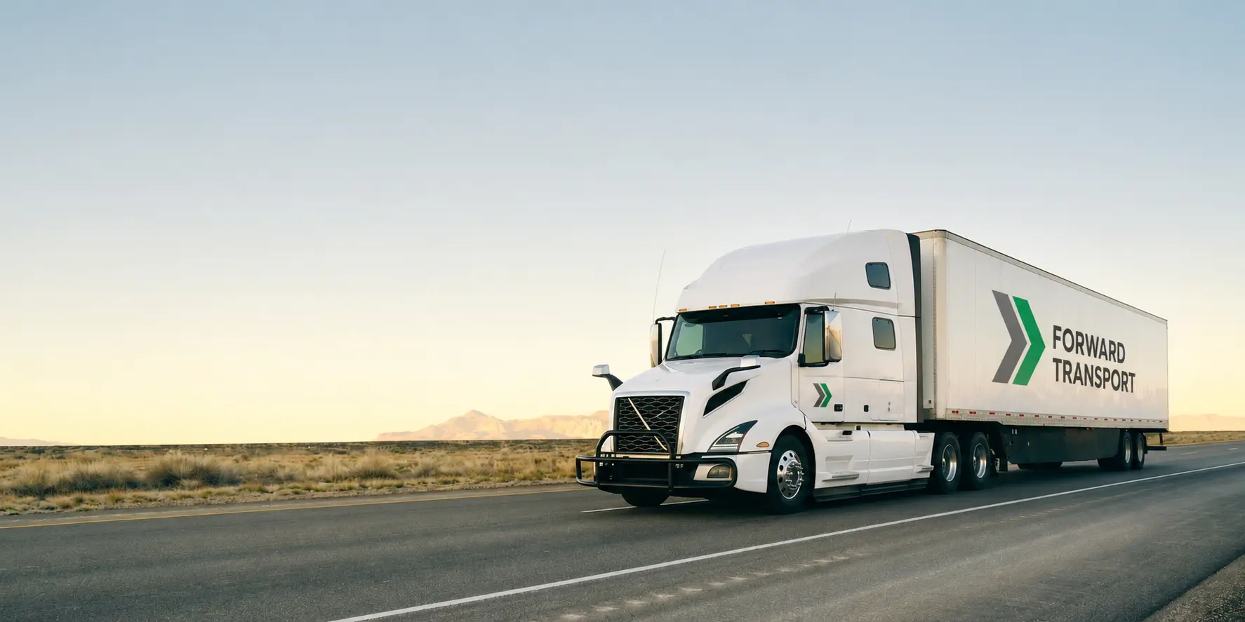 White Forward Transport semi truck at a distribution center in the early morning